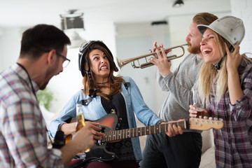 Fototapeta premium Friends having fun and partying in house and playing music