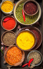Ground spices in bowls on a wooden tray.