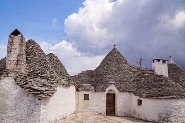 Fototapeta na wymiar Beautiful white houses of Alberobello twon in Italy with their specific conical stone shingle roofs