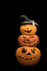 Three pumpkins with different faces for the holiday of Halloween on a black background