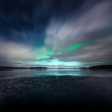 Northern Lights behind fast moving clouds in Kurjenrahka National Park, Finland