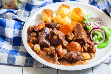 Beef Bourguignon stew served with baked potatoes
