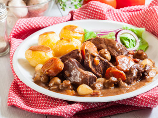 Beef Bourguignon stew served with baked potatoes