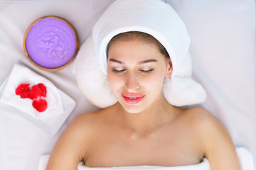 Top view of young beautiful woman spa face and scrub skin at spa salon. concept of relaxing spa and face massage.