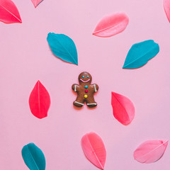 gingerbread man among the colored feathers. the concept of new year and Christmas. winter holidays. flat lay.