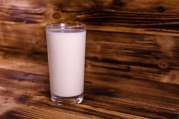 Full glass of milk on a wooden table