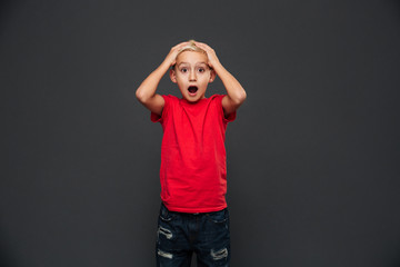 Shocked little boy child standing isolated