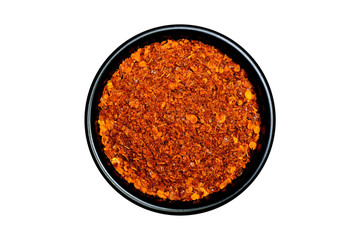 Hot red chili peppers powder in a black bowl isolated on white background