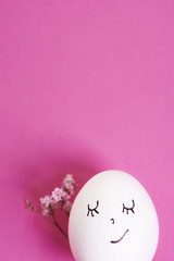 Egg with face isolated on pink bacground.
