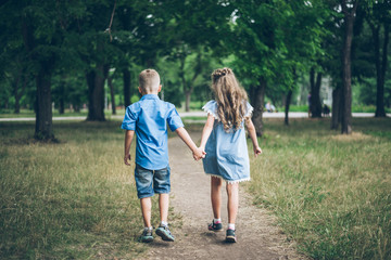 A little boy and girl walking together and holding each other hands
