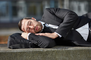Überarbeiteter Business Mann schläft im Freien