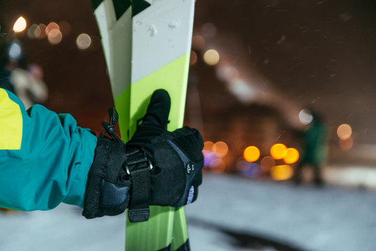 mans hand hold ski on the top of the snowed hill
