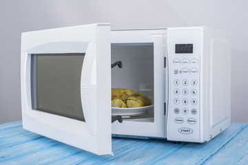 white microwave oven, on a blue wooden surface for heating food