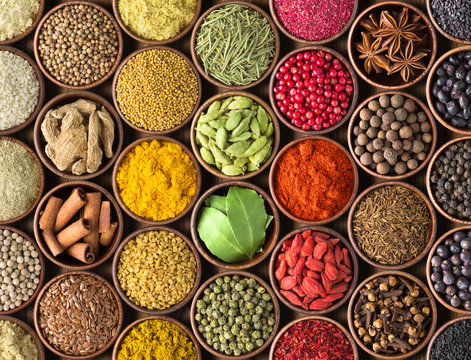 Spices and herbs background. Condiments on the table spread out by a rainbow