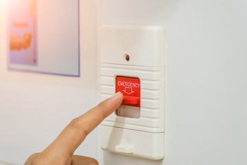 Closeup patient hand press emergency button in the hospital restroom.