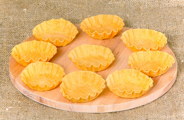 Empty tartlets on a wooden board. Billets for sweet dessert and snacks. Pre-prepared meal for cooking. Horizontal image.