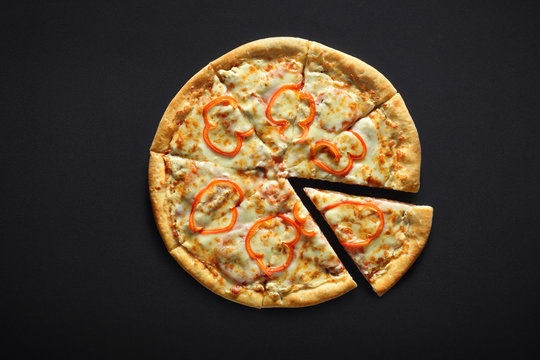 Pizza with ham pepper and cheese on a black stone background