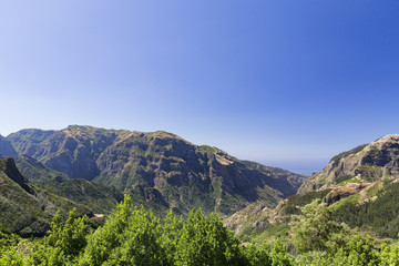 Fototapeta na wymiar Wide angle view of mountains and valleys in the late morning on the island of Madeira in Portugal.