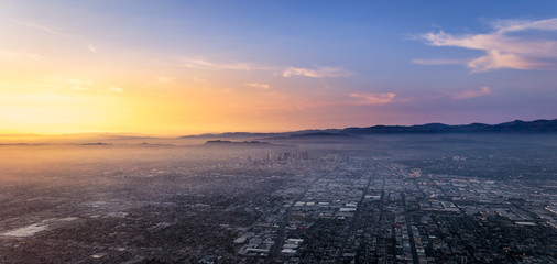 Beautiful sunset over the center of Los Angeles viewed from an rising airplane