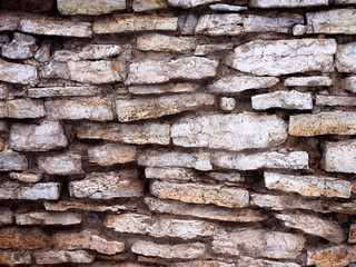 A wall made of old flat stones. Not an even masonry.