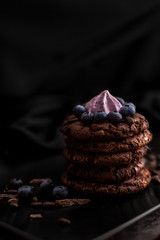  Black biscuits with blueberries on a black matte plate