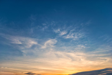Sky blue and orange light of the sun through the clouds in the sky