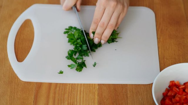 Female hands chopped parsley