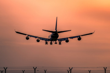 Airplane landing at sunset