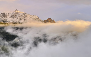 Fototapeta na wymiar peak of mountain in the clouds at sunset 