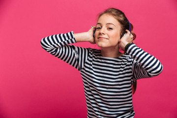 Pretty teenage girl listening music with headphones.