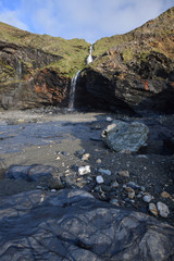 Waterfall and cave Tregardock Beach Cornwall