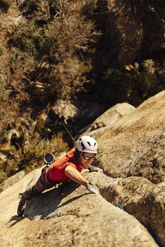 Rock climber ascending a steep granite crack self protected