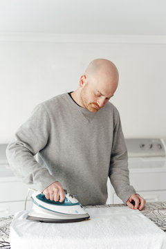Front view of man ironing a towel