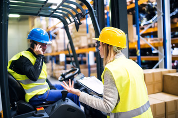 Young warehouse workers working together.
