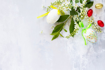 Easter background. Colorful Easter background with colored eggs and sweets on a gray stone background with copy space. Flat lay. Top view with copy space.