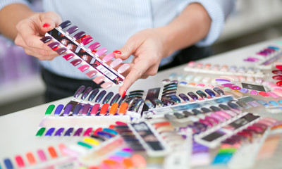 Woman choosing colorful artificial nails at beauty store, closeup