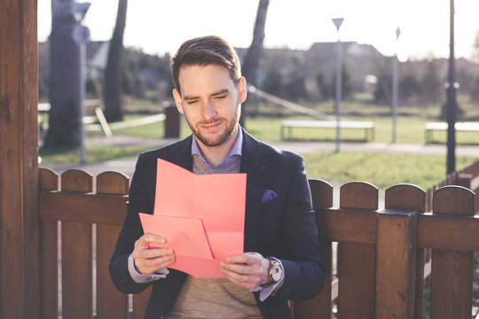 Handsome elegant man reading a love letter on Valentines Day.