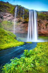Picturesque landscape of a mountain waterfall and traditional nature of Iceland.