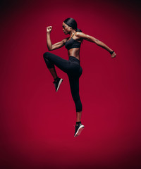 Fototapeta na wymiar African female athlete jumping and stretching