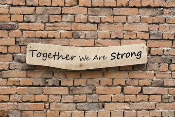 Fototapeta na wymiar Together We Are Strong written on wooden sign