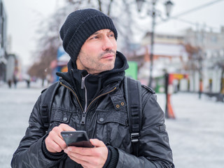 Tourist man looking for th place in GPS application in his smartphone.