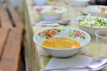People eat healthy meals and drink alcohol at festive table served for party. Friends celebrate with organic food on wooden table top view. Man pour wine drink to woman