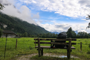 Fototapeta na wymiar Backpack on bench beautiful mountain view Bavaria Germany Alps