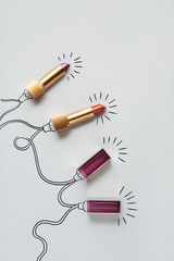 Beautiful holiday / Creative concept photo of lipstick as christmas lights on grey background.