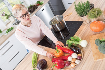 Young woman cooking vegetables in her kitchen