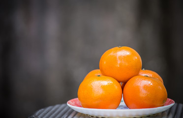 Orange in plate with gray background.