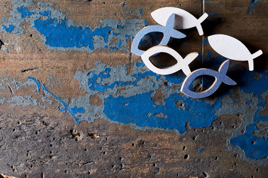 Metal Christian fish shapes on wood background