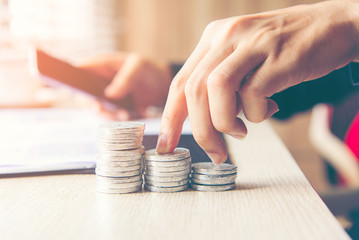 Businessman hand walking stack of coin money  for the investment financial report.  Investment concept..