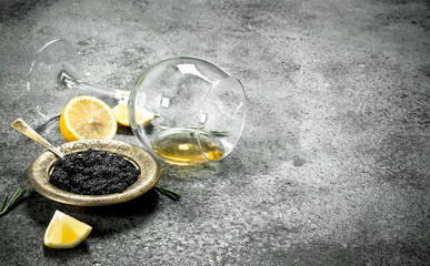 Black caviar with white wine and lemon.