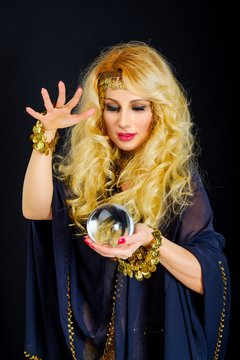 Woman fortune teller with crystal ball portrait on black